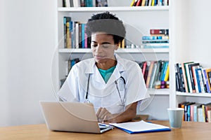 Afro american female doctor at computer