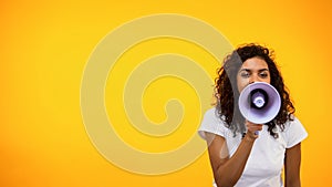 Afro-American female shouting in megaphone, public relations, social opinion photo