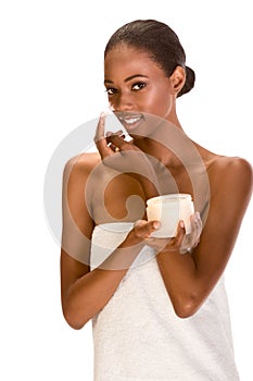 Afro-American girl wrapped in towel cream on face