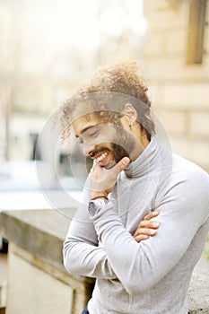 Afro american gladden businessman wearing grey turtleneck sweater and having curly brown hair.