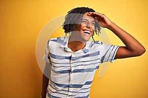 Afro american man with dreadlocks wearing striped shirt over isolated yellow background very happy and smiling looking far away