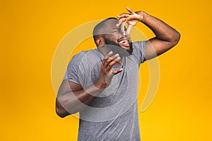 Afro american man isolated against yellow background smelling something stinky and disgusting, intolerable smell, holding breath photo