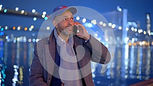 Afro-American man standing at Brooklyn Bridge New York at night - street photography