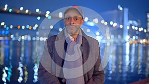 Afro-American man standing at Brooklyn Bridge New York at night - street photography