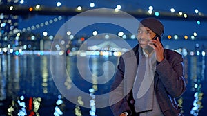 Afro-American man standing at Brooklyn Bridge New York at night - street photography