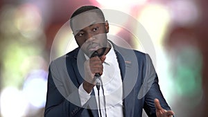 Afro-american man talking into microphone.