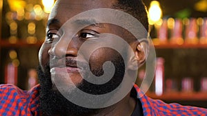 Afro-American man upset about favorite sports team loss, watching match in pub