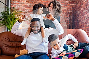 afro american mixed-raced family looking at camera in cozy summer day light in living room