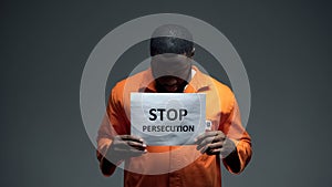 Afro-american prisoner holding stop persecution sign, racial discrimination