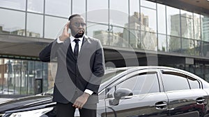 Afro-American security worker listening boss directions in earphones, security