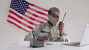 Afro-american soldier using computer and portable radio set