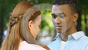 Afro-american teen boy adjusting hair of girlfriend, admiring beauty, pure skin