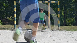 Afro-american teen male missing goal, friends playing football in yard, hobby