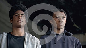 Afro-american teenagers looking forward, going to commit crime, urban danger