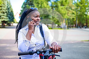 Afro american woman activate and prepay a rental e-scooter or an e-bicycle on the street