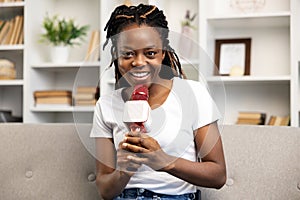 Afro American Woman Enjoying Podcasting with Microphone at Home photo