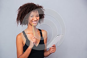 Afro american woman holding notebook with pencil o