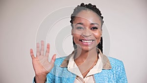 Afro american woman smiling and waving hand hello.