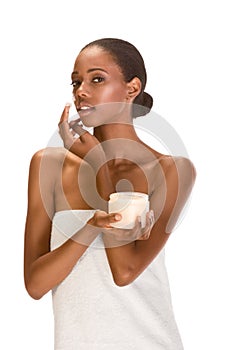 Afro-American woman in towel put cream on face