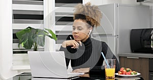Afro american woman wearing headphones studying online