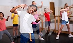 Afro boy showing dance elements at class
