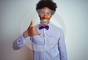 Afro business man wearing striped shirt and purple bow tie over isolated white background doing happy thumbs up gesture with hand