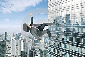 Afro businessman running upward on a skyscraper