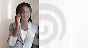 Afro Businesswoman Talking On Smartphone Near Window In Office