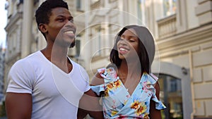 Afro couple having romantic date outdoors. Man and woman walking in city