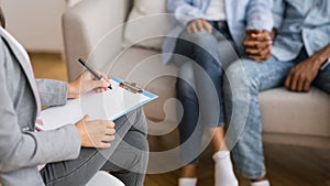 Afro couple holding hands on couch during marriage counseling session