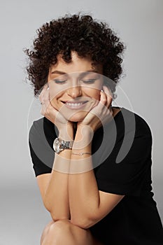 Afro curly hair fashion woman, natural makeup and cosmetics. Beauty face smile portrait of a woman with black curly hair, afro