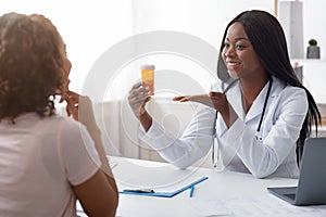 Afro female doctor prescribing medicine to patient