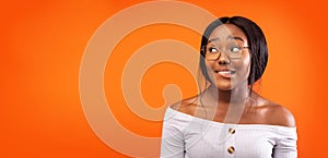 Afro Girl Biting Lips Standing Over Orange Studio Background, Panorama