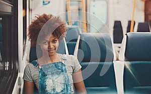 Afro girl in evening empty suburban train