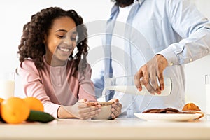 Afro Girl And Her Dad Pouring Milk In Cereal