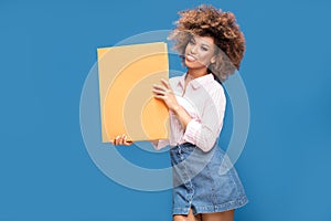 Afro girl showing blank yellow board.