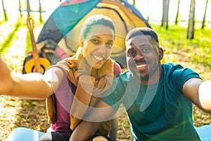 afro latin couple in tent taking selfie using modern smartphone