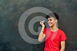 Afro latin young man talking by mobile phone against a wall