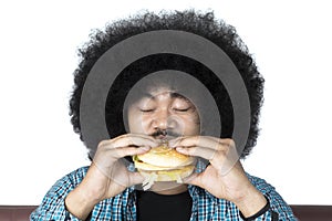 Afro man eating a delicious hamburger