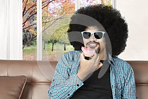 Afro man eats tasty donuts