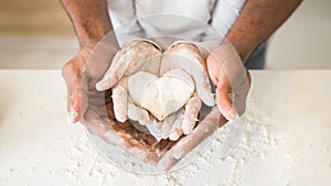 Afro man hands holding child hands with heart shaped pastry