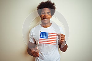 Afro man holding United Estates of America USA flag standing over isolated white background with a happy face standing and smiling