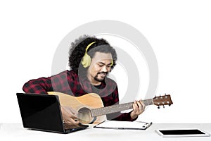 Afro man plays a guitar on the studio