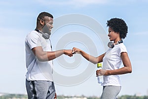 Afro Man And Woman Giving Fist Bump After Jogging Outdoor