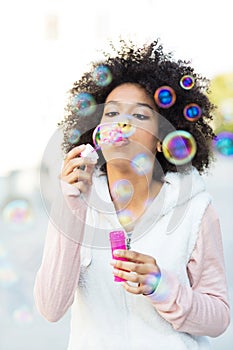 Afro woman blowing soap bubbles