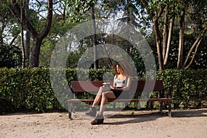 Afro woman reading a book on a bench