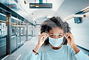 Afro woman wearing face mask in metro station