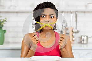 Afro woman with yellow measuring tape around her mouth