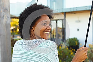 Afro young african american woman smiling in backyard outside house