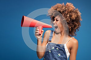 Afro young girl screaming by red megaphone.